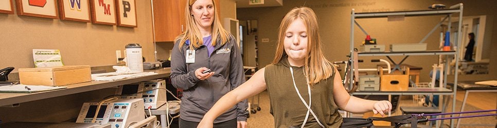 Photo of a rehab specialist working with a young athlete on balance